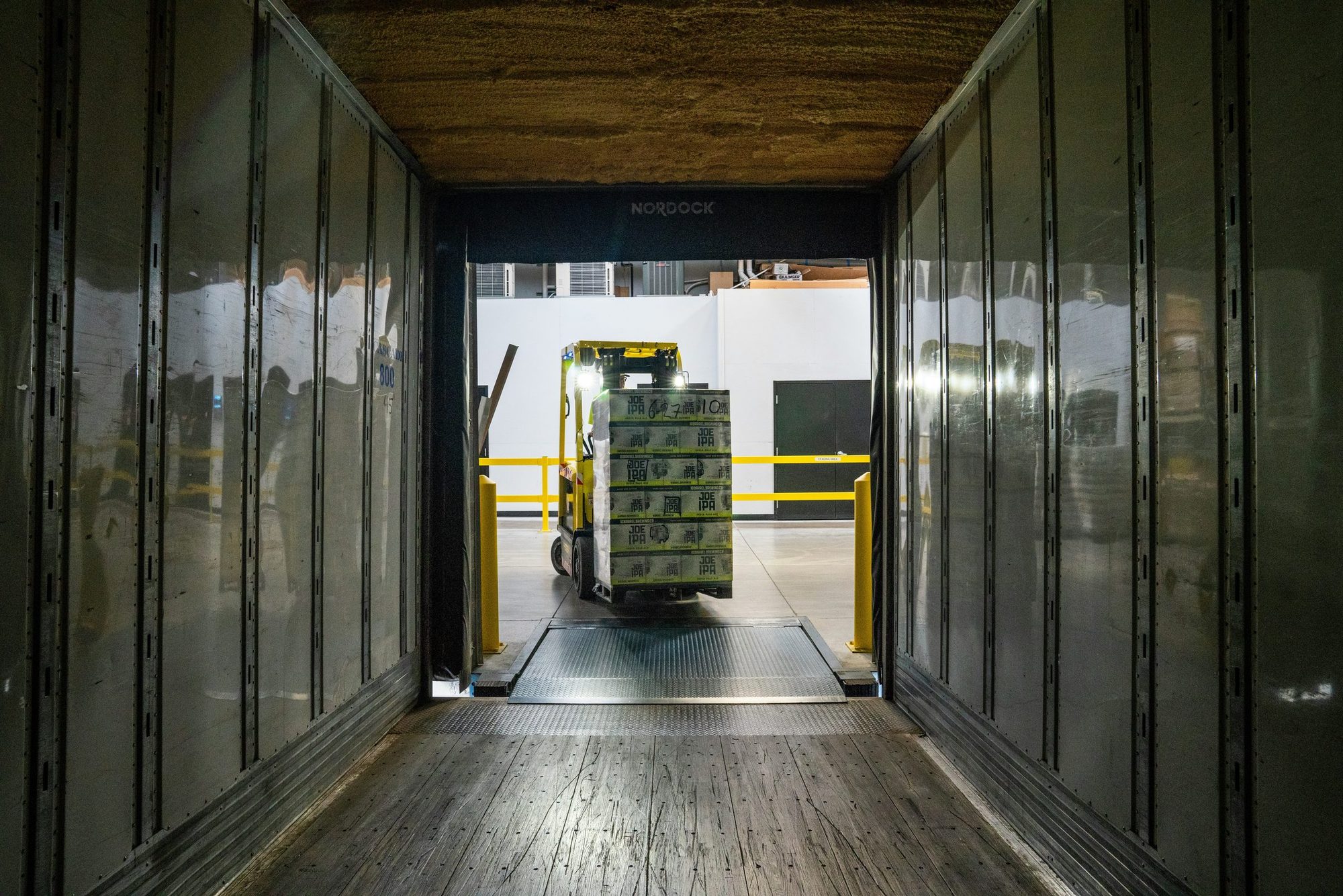 Forklift loading palletised cargo into a refrigerated trailer